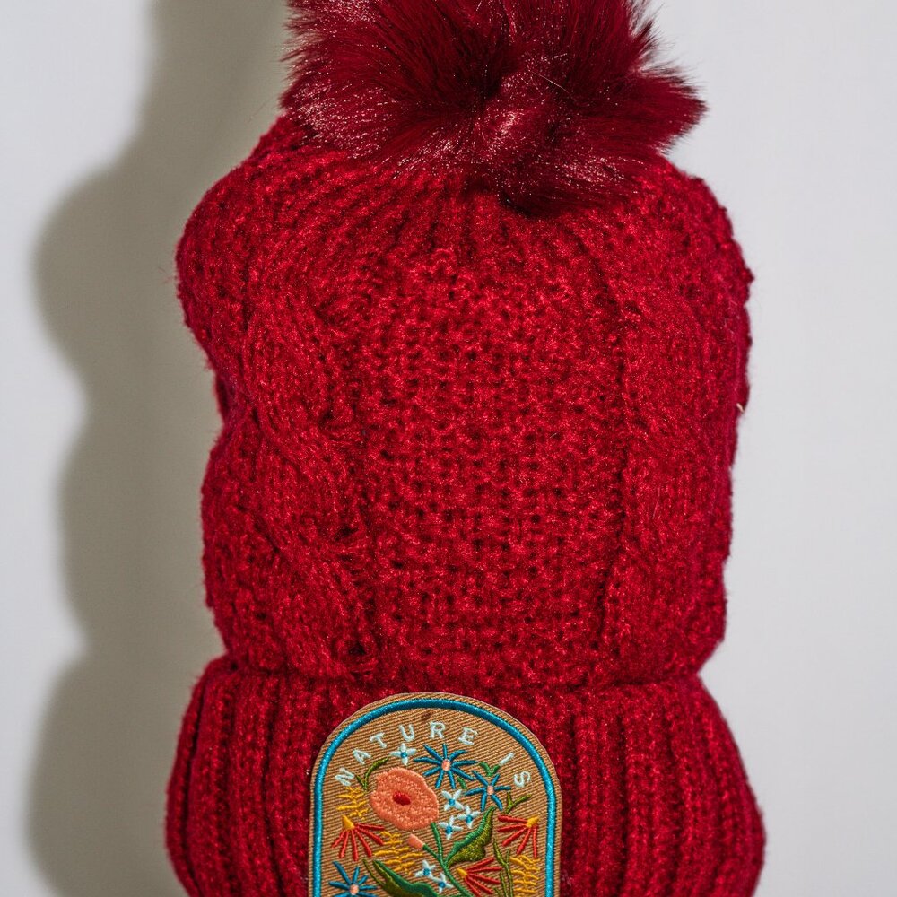 Red stocking cap with "Nature is Magic" patch and fuzzy lining